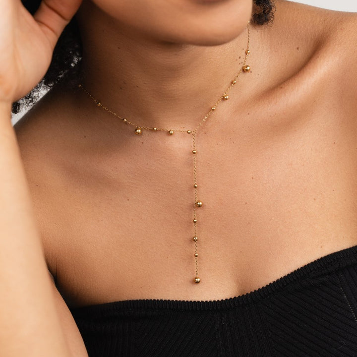 Collar con perlas doradas y borlas